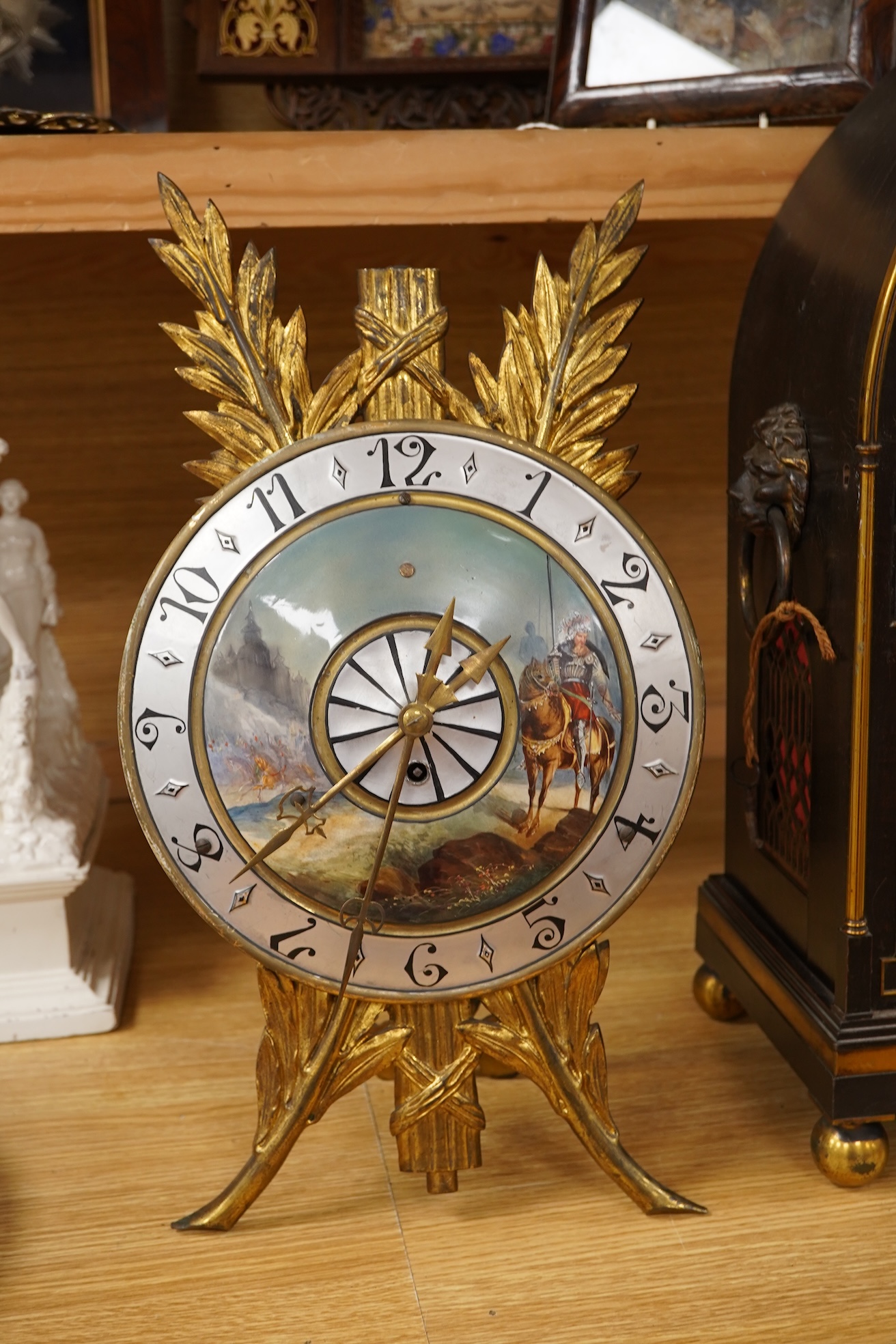 A Regency ebonised and brass inlaid lancet-shape bracket clock, with key and a painted pottery strut timepiece, largest 55cm high (2)